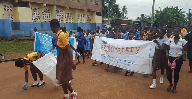 Club members carry banner and garbage bags as clean-up day begins